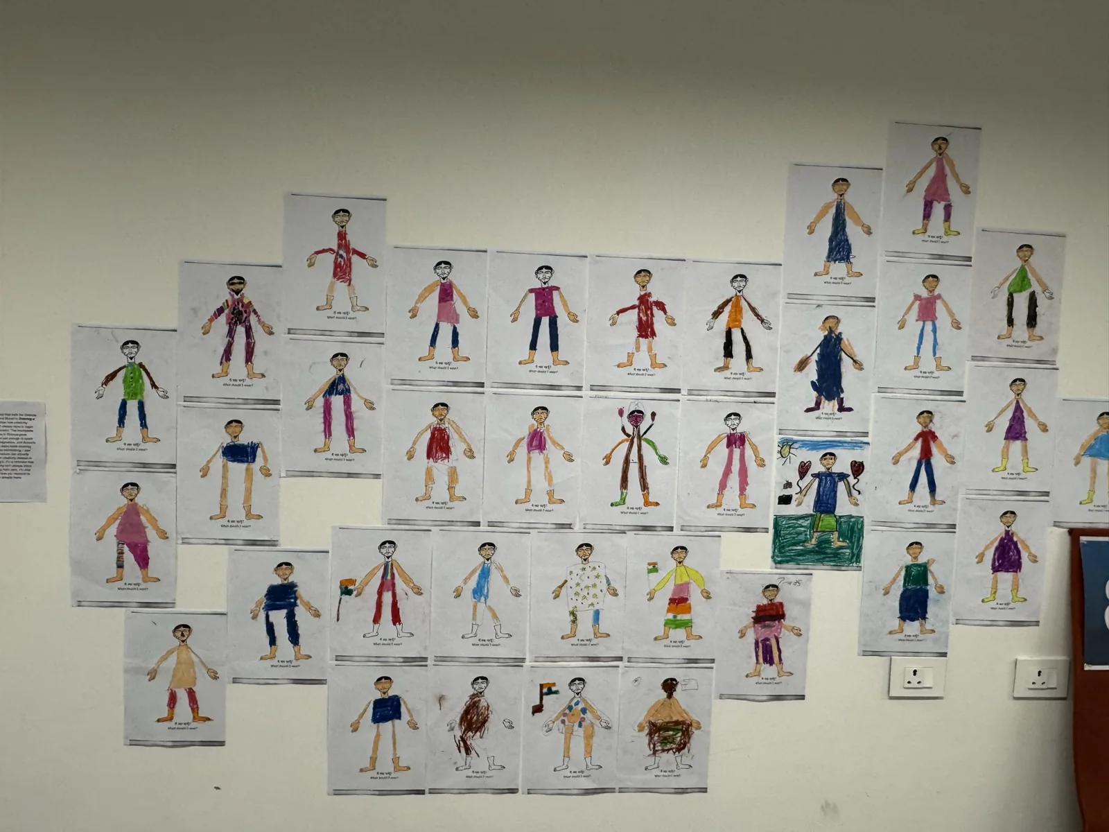 Rows of colourful character drawings installed on an exhibition wall