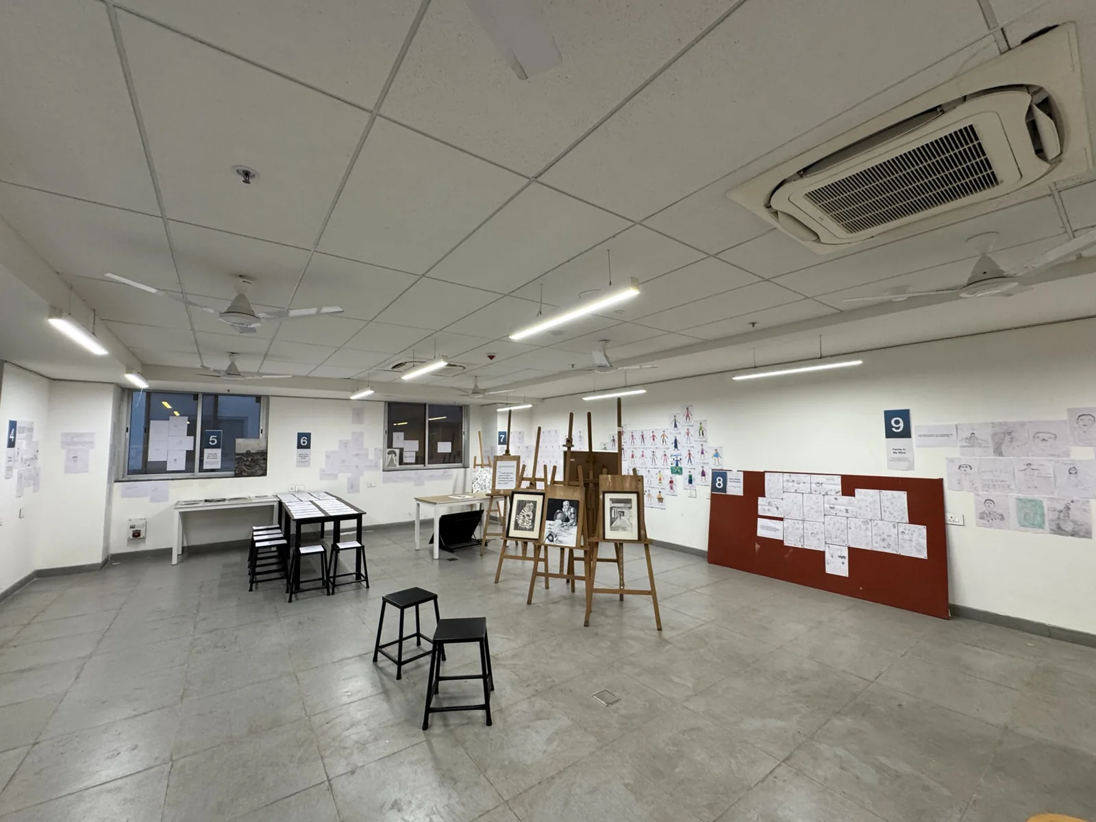 The Drawing Studio exhibition, photographed by Arjun, with drawings across walls, tables, and easels