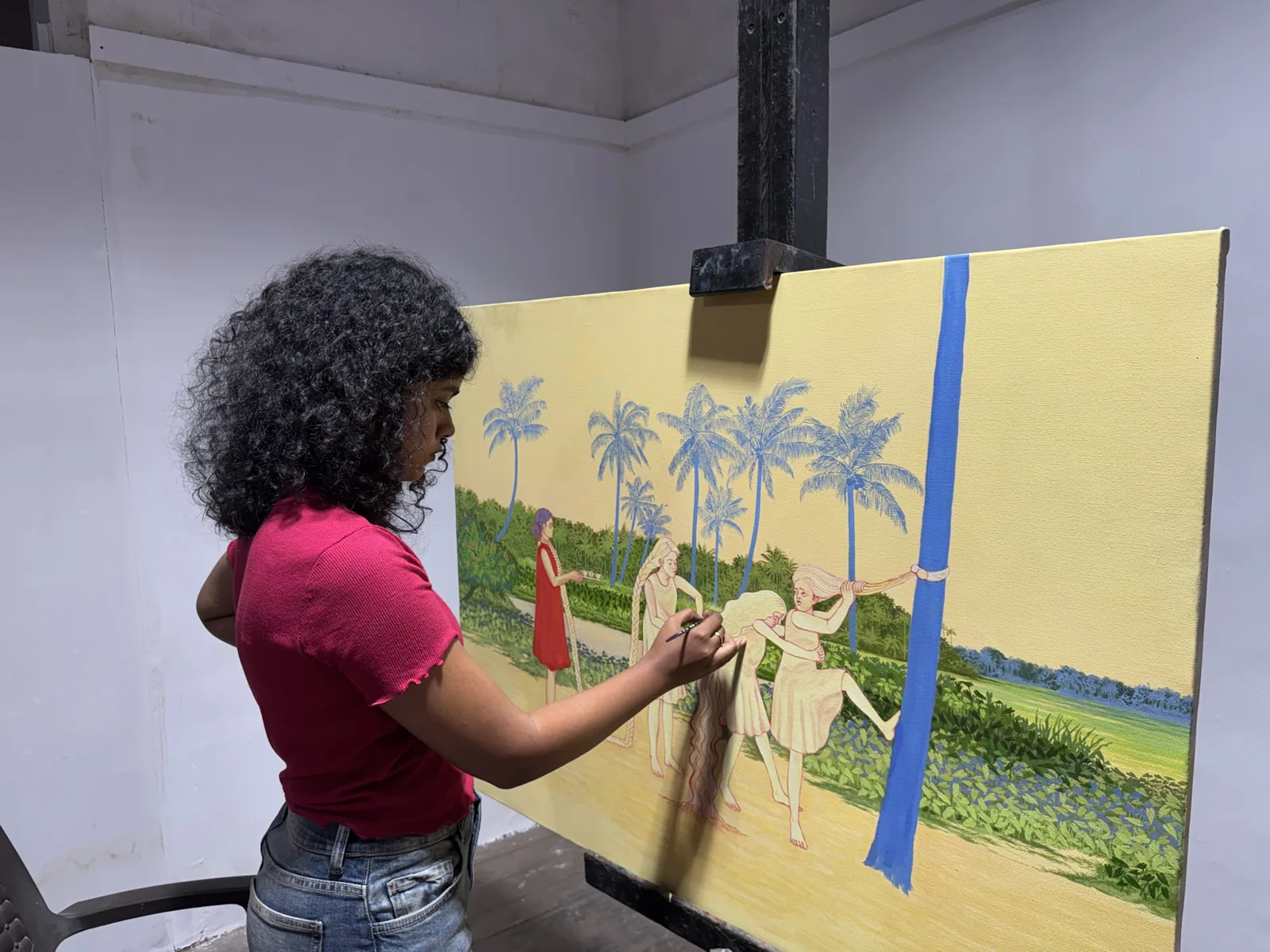 A person standing beside and gesturing toward a colourful painting
