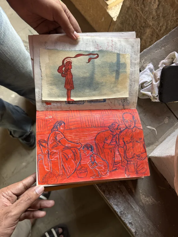 An open sketchbook with two coloured figurative studies